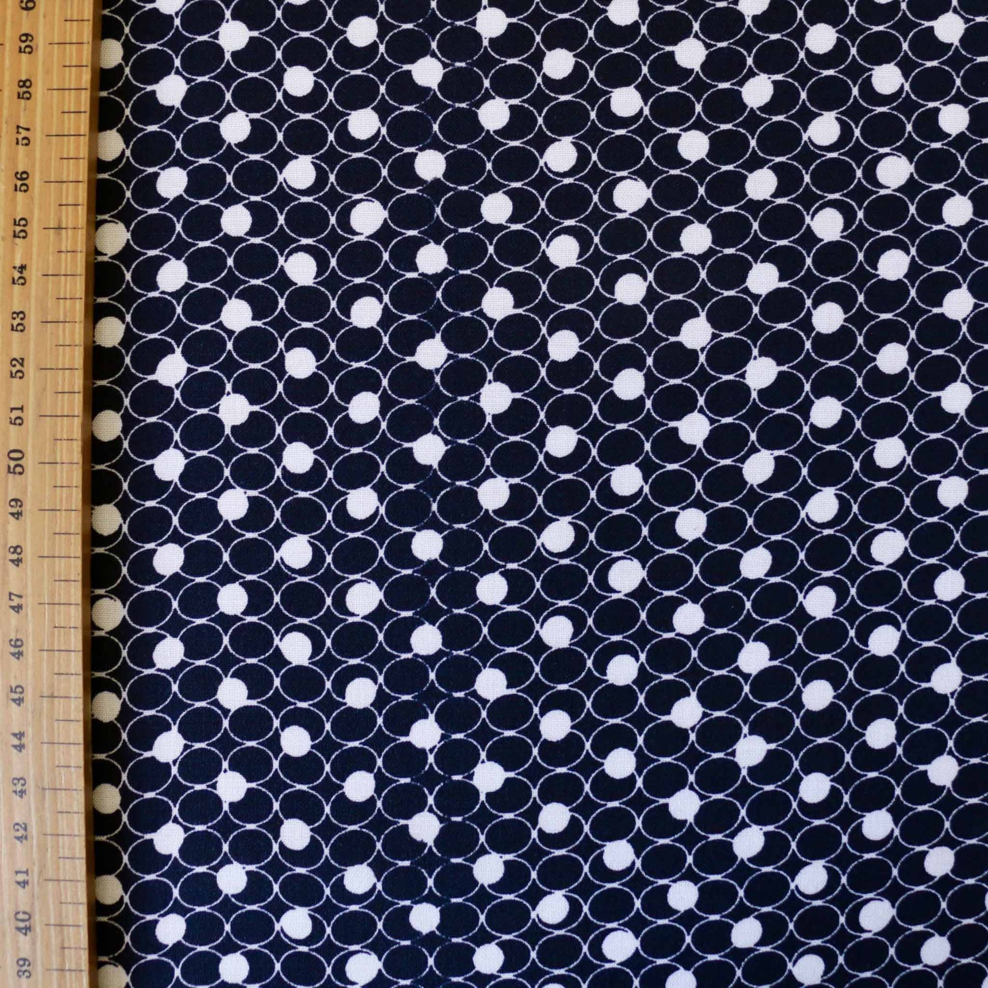 metre navy blue viscose challis dressmaking fabric with white circles printed in geometric design