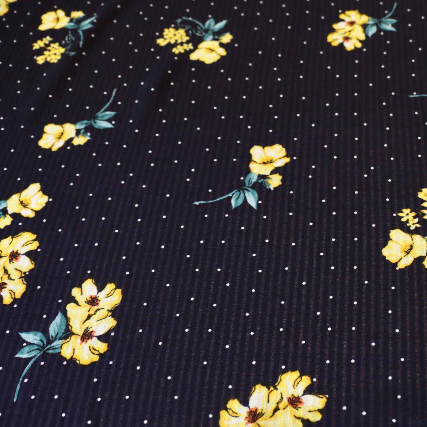 white polka dots and yellow flowers printed on navy blue georgette dressmaking fabric