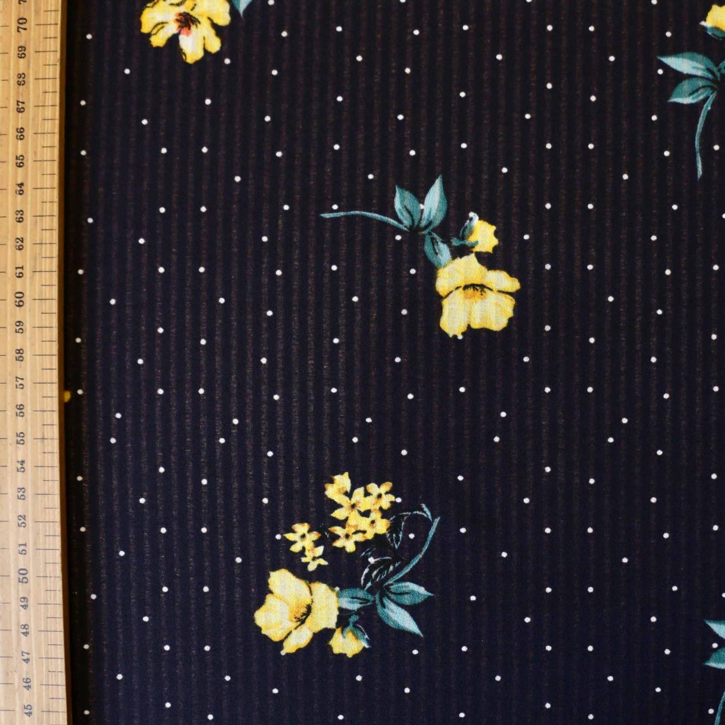 metre nevy blue georgette dressmaking fabric with white polka dots and yellow floral design