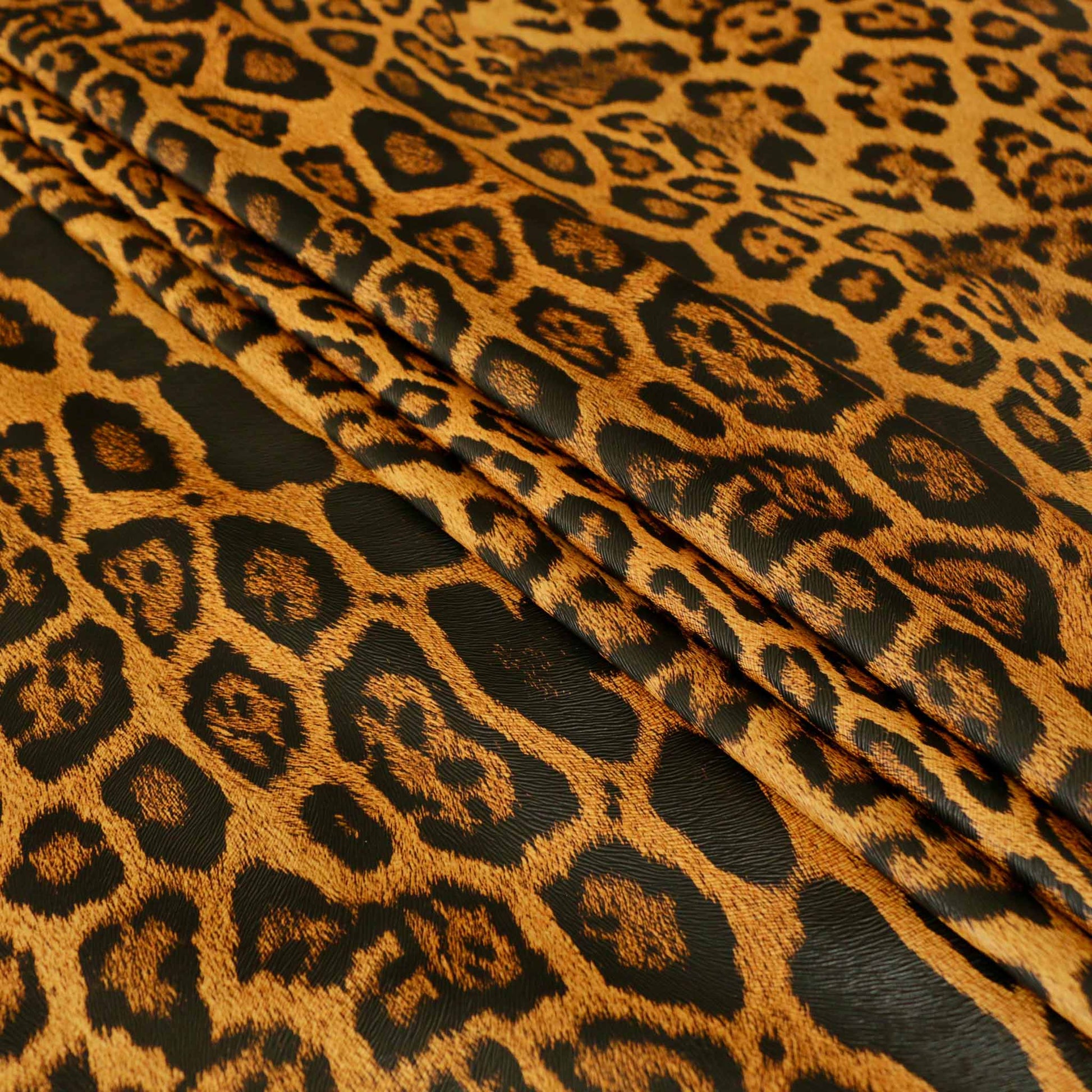 orange and black jaguar skin animal print faux leather vinyl pvc dressmaking fabric