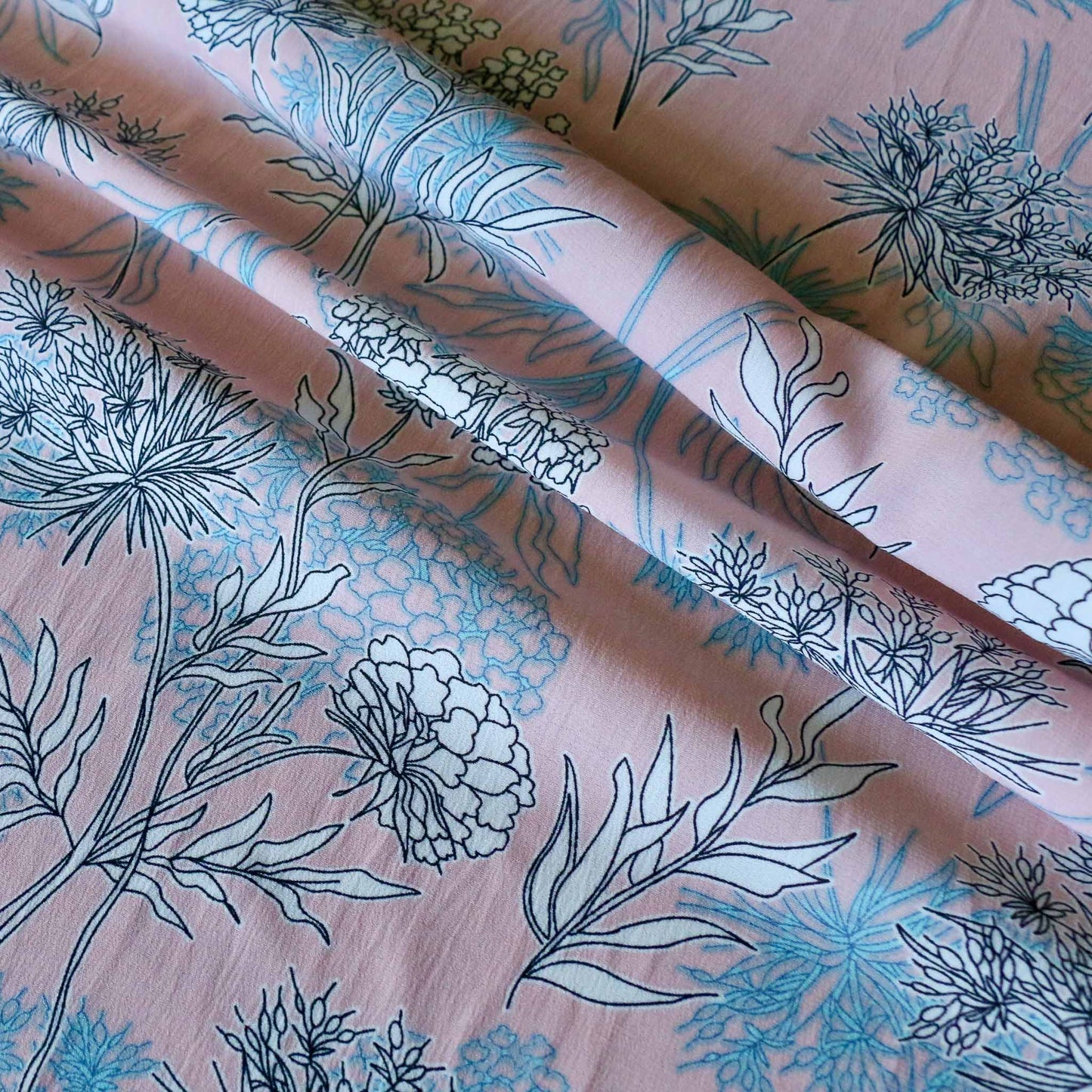 white flowers printed on pink chiffon stretchy polyester dressmaking fabric