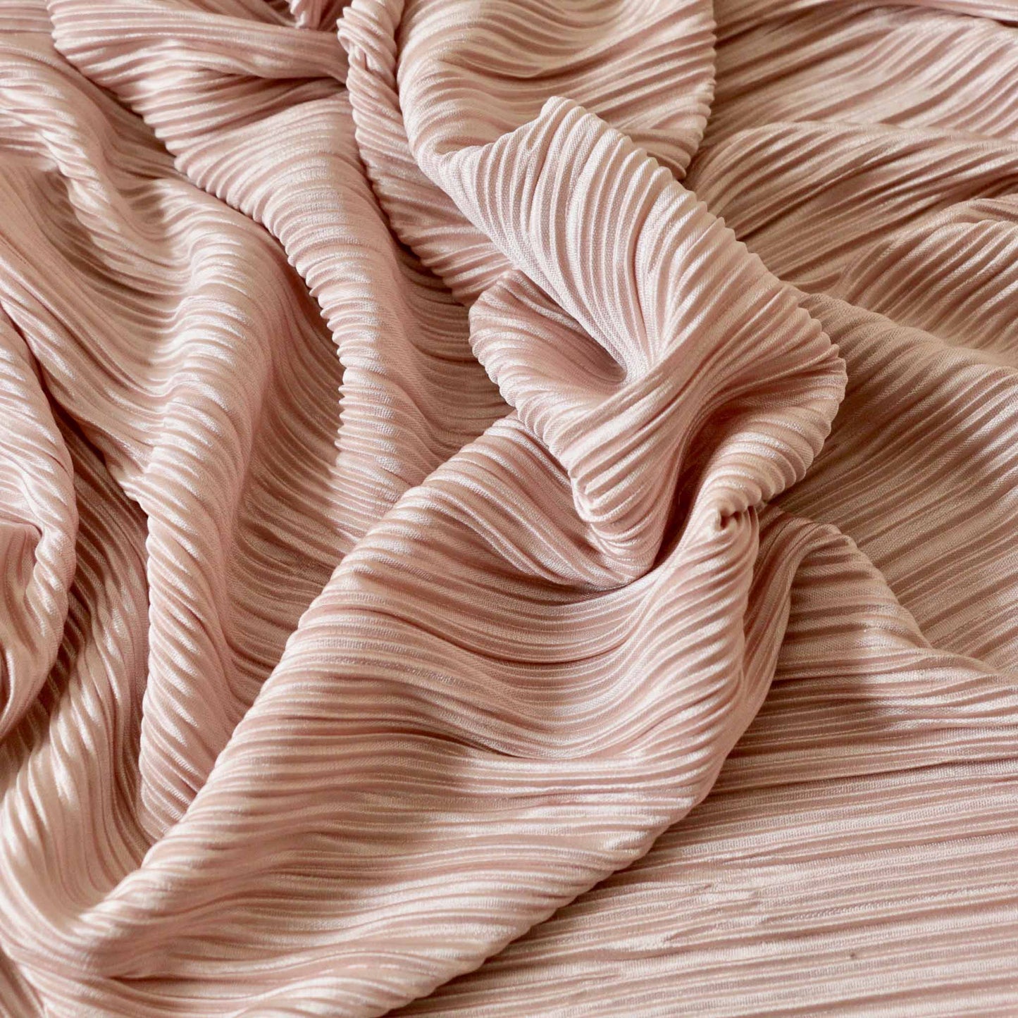 pink pleated plisse dressmaking fabric with wavy stripe design