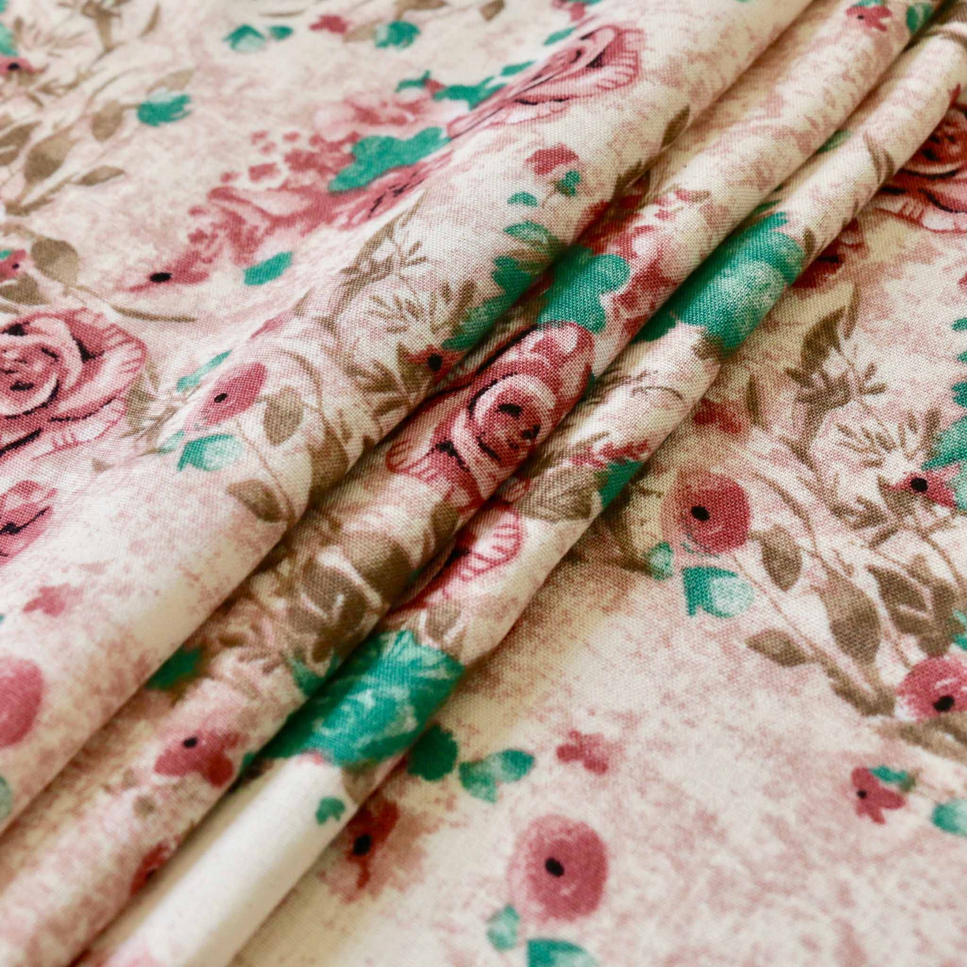 folded viscose challis dressmaking fabric in dusty pink with floral printed design