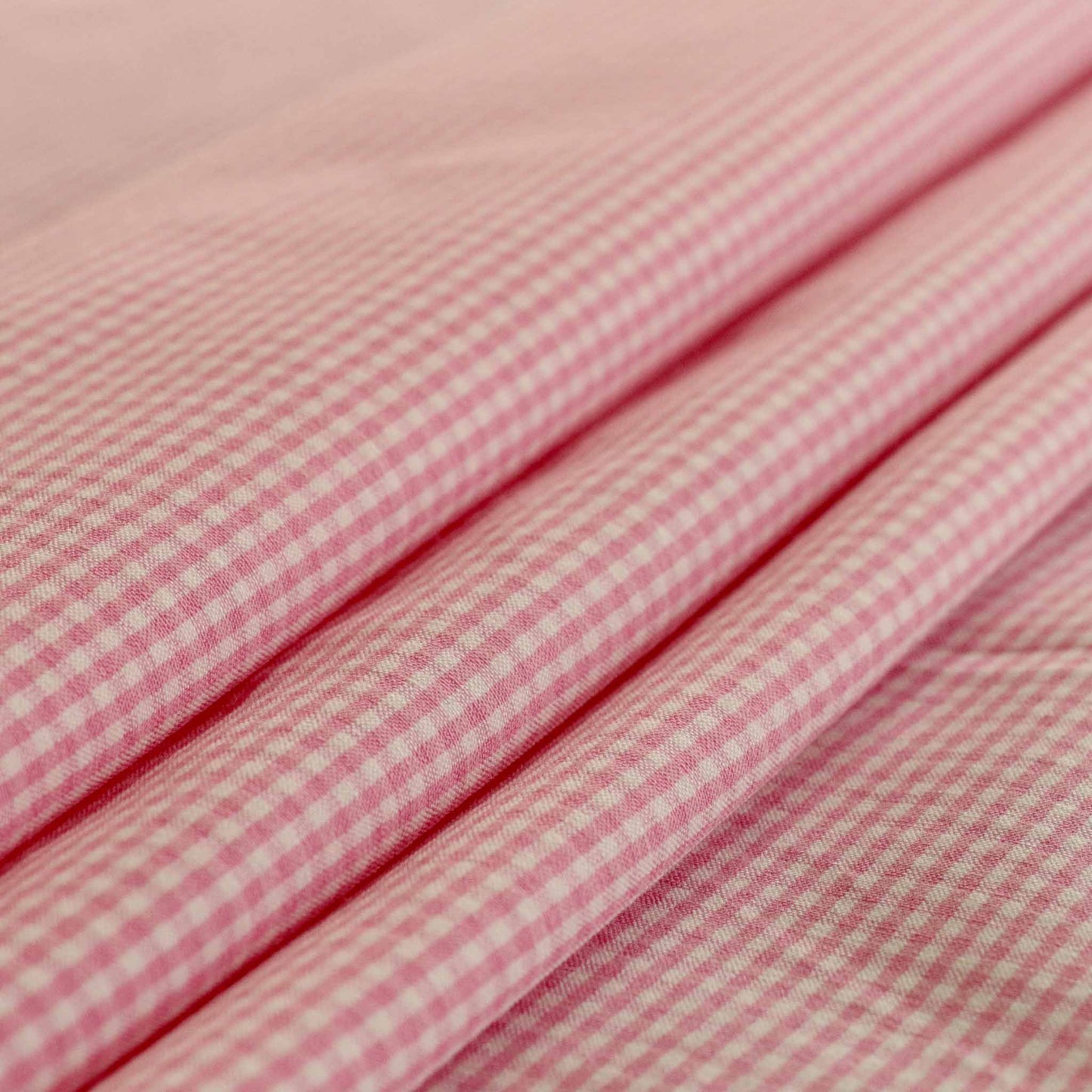 folded bengaline suiting pink and white dressmaking fabric with gingham check design