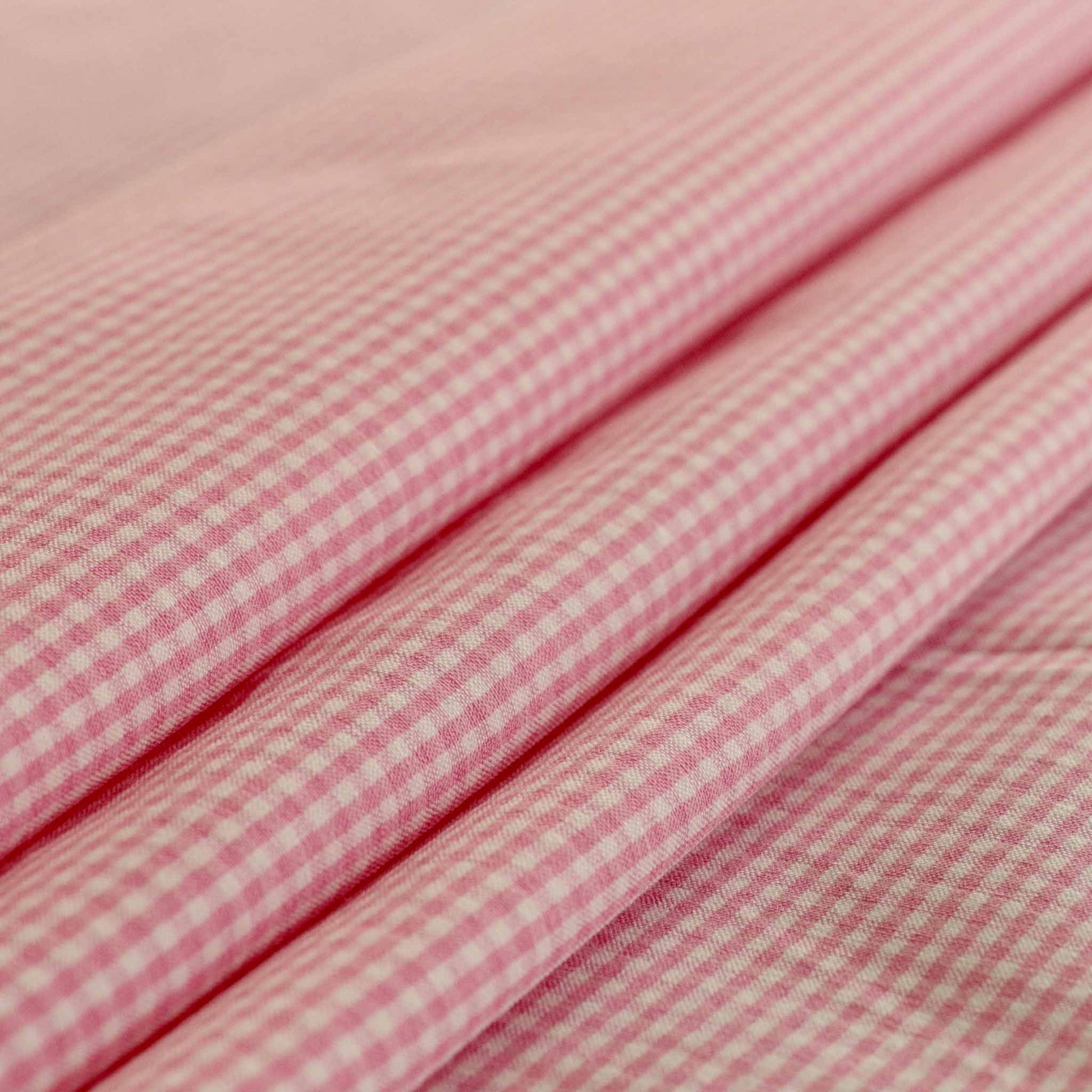 folded bengaline suiting pink and white dressmaking fabric with gingham check design