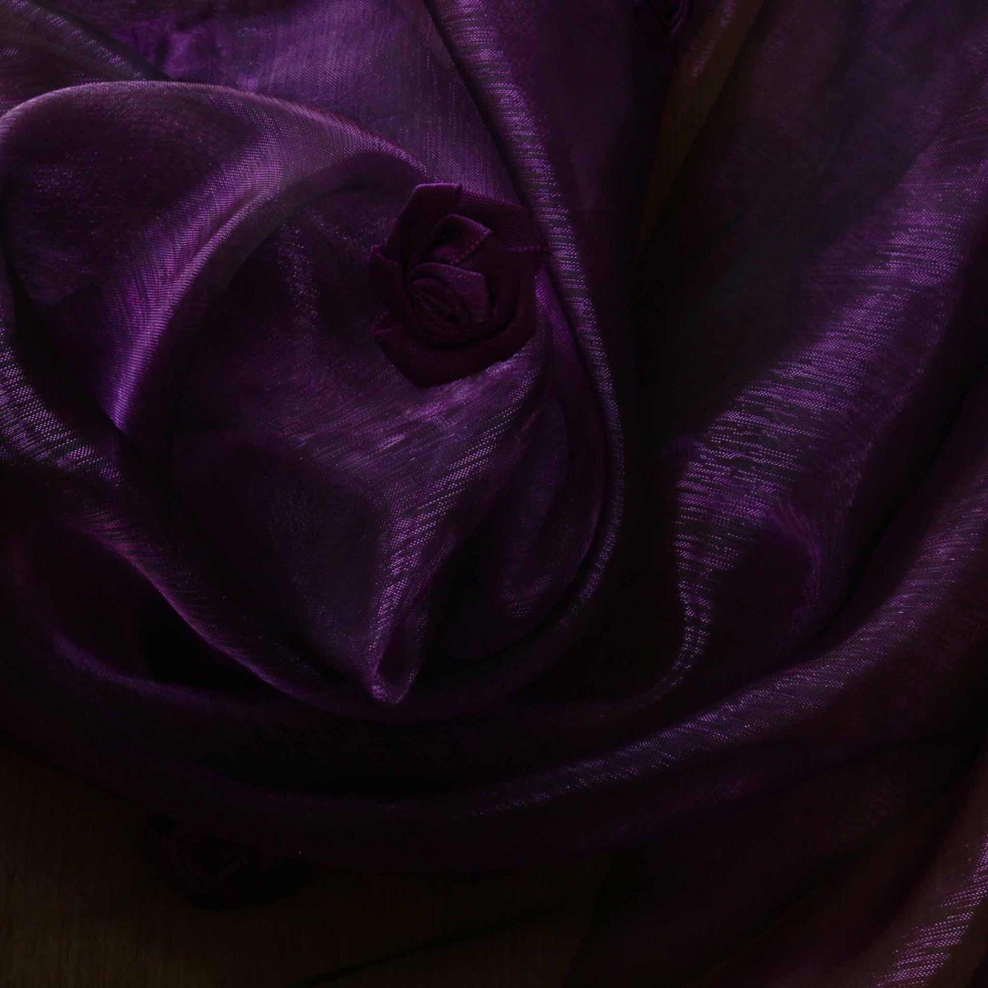 purple organ dressmaking fabric with satin rose embellishment