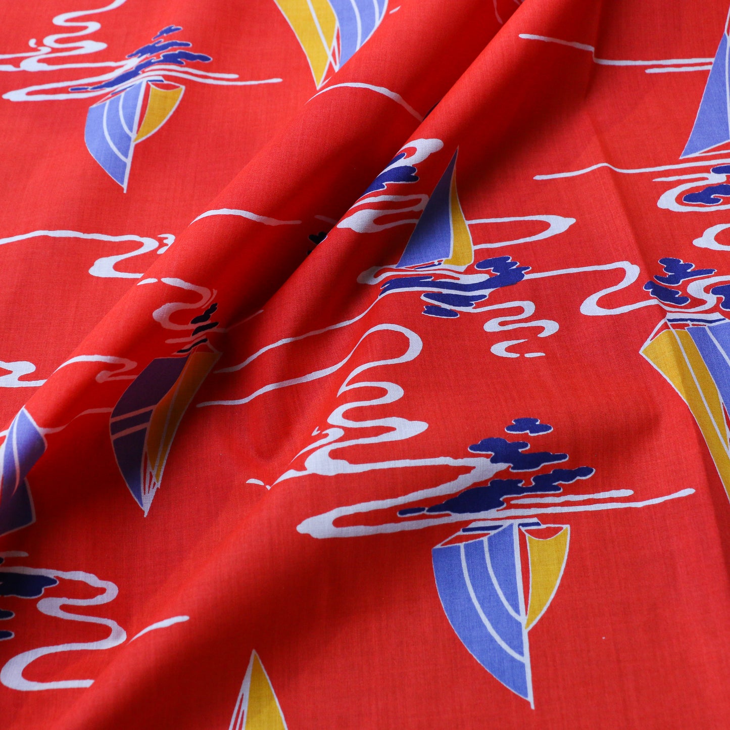 folded red vintage cotton poplin deadstock sustainable fabric with printed nautical boat pattern