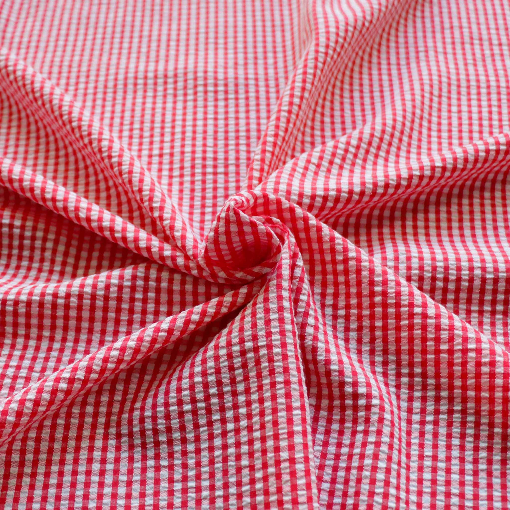 seersucker dressmaking fabric in red and white gingham style design