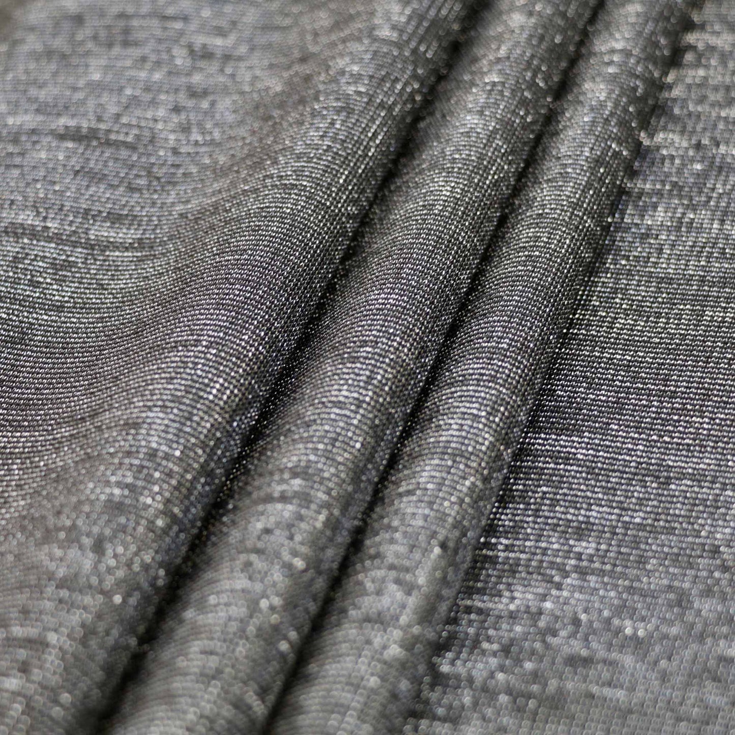 folded black ponte roma fabric for dressmaking with silver shimmer texture