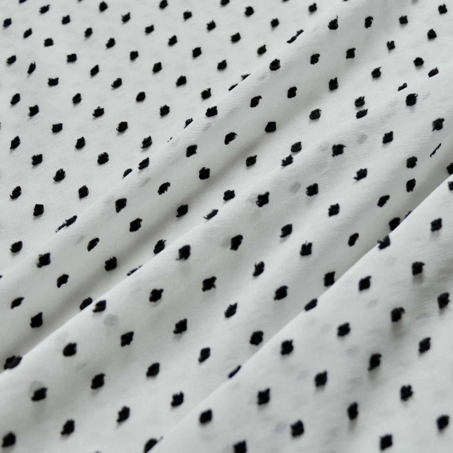 white chiffon dressmaking fabric with black swiss dot dobby pattern