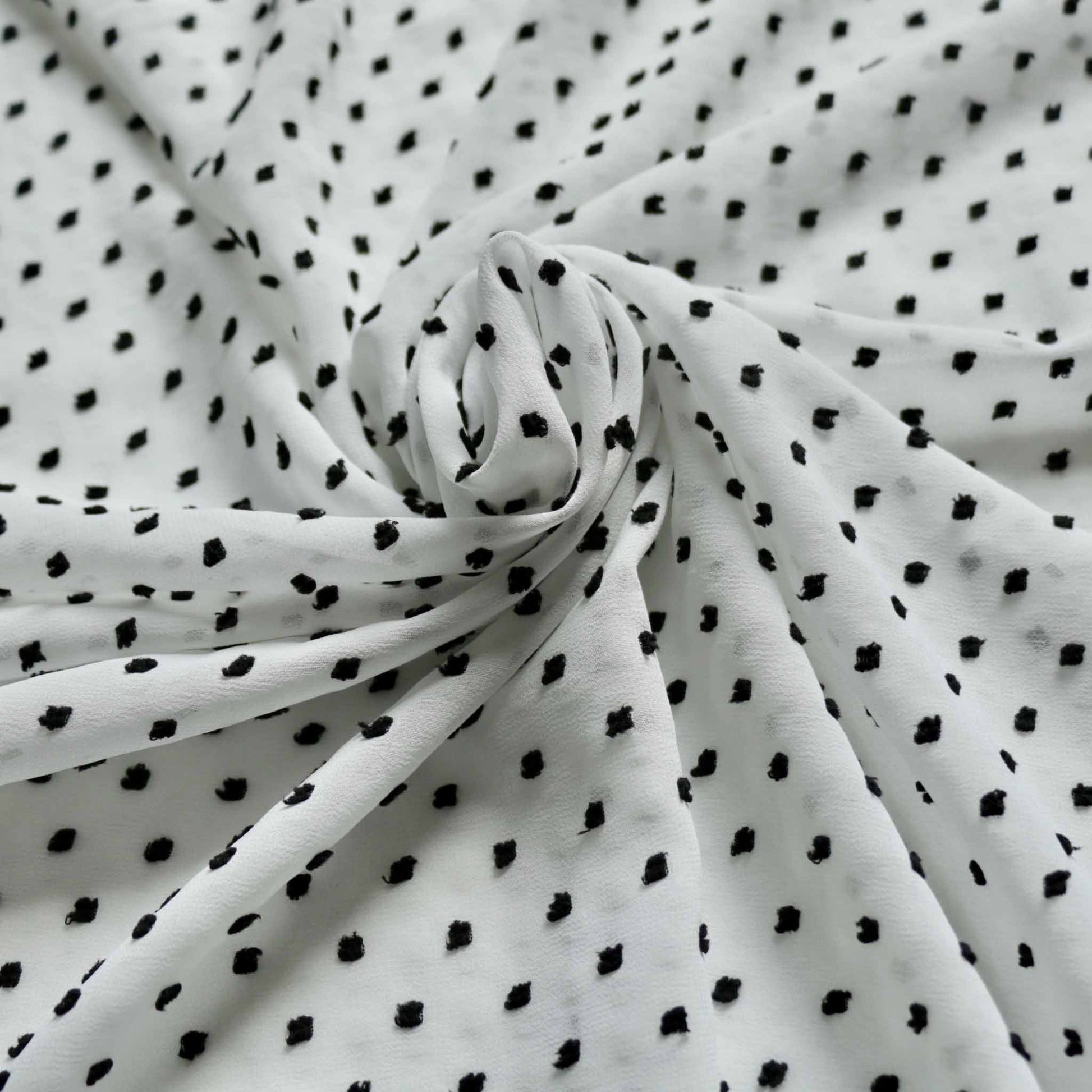 white chiffon dressmaking fabric with black dobby swiss dot design
