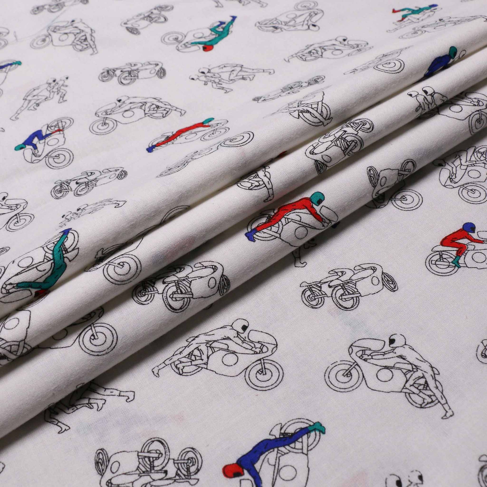 folded white brushed cotton dressmaking fabric with motocross design
