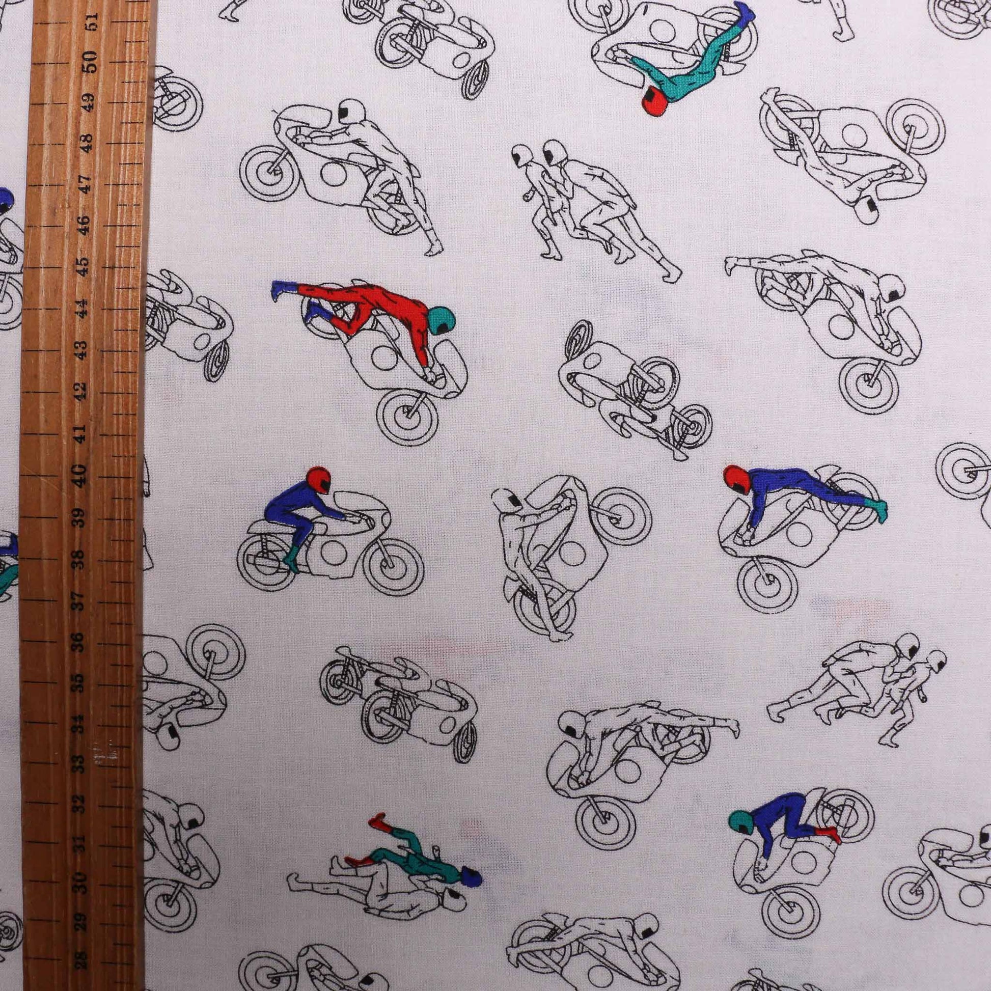 folded brushed cotton dressmaking fabric in white colour and motocross design