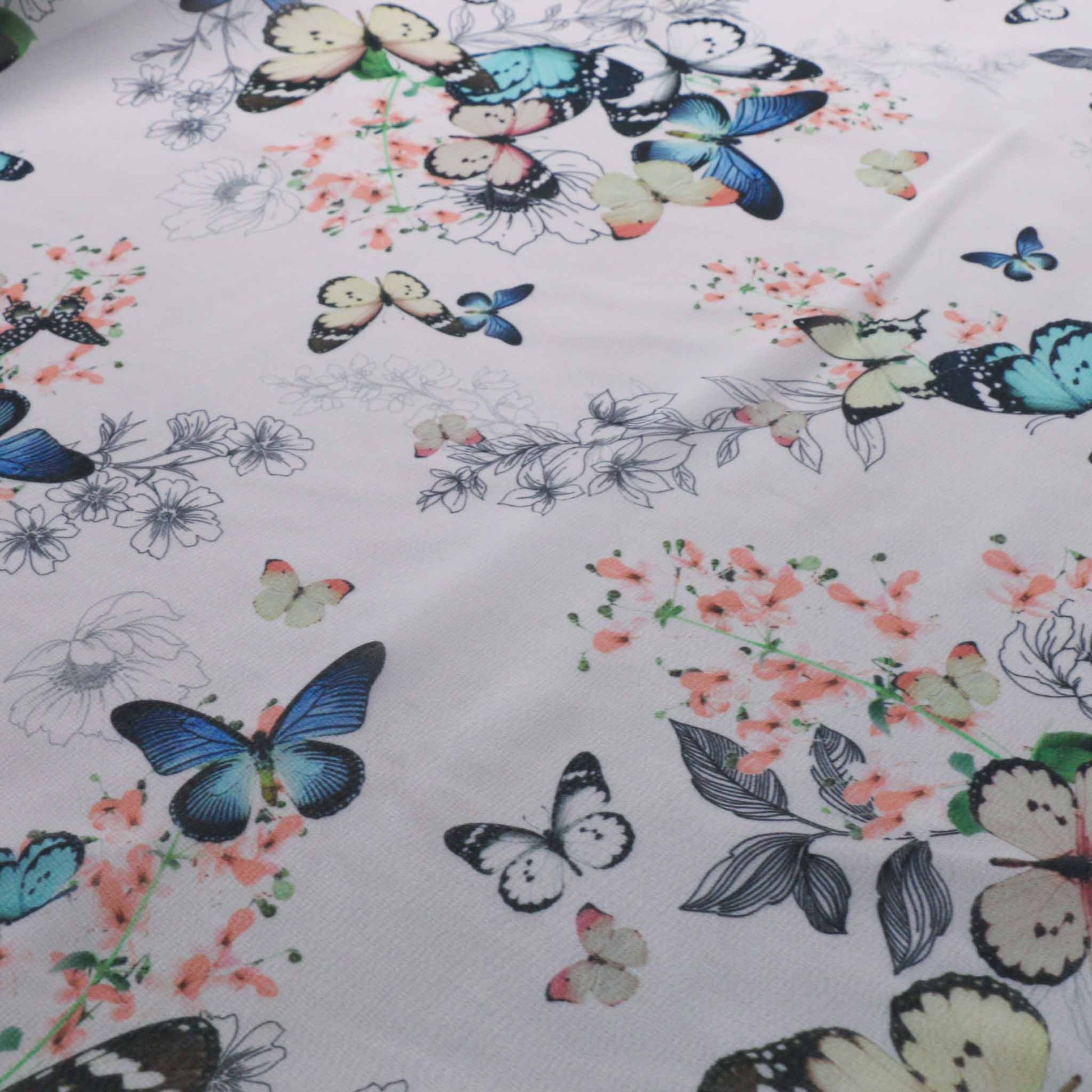 white chiffon dressmaking fabric with printed blue butterfly and pastel flowers