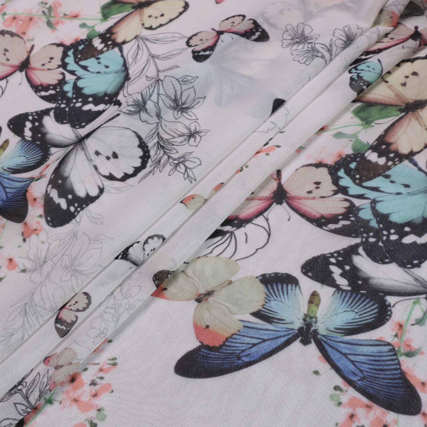 white chiffon dressmaking fabric with blue butterfly design with pastel floral print
