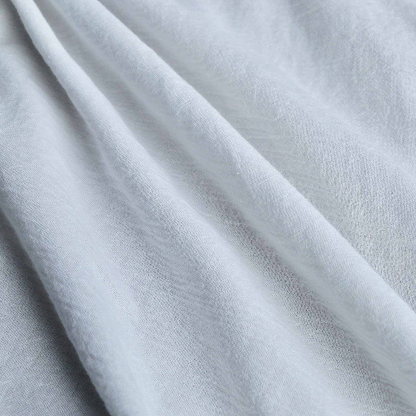 close up of crinkle cotton gauze dressmaking fabric in plain white