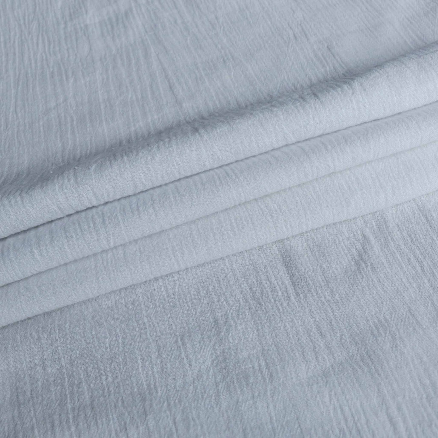 folded cotton gauze dressmaking fabric in plain white colour