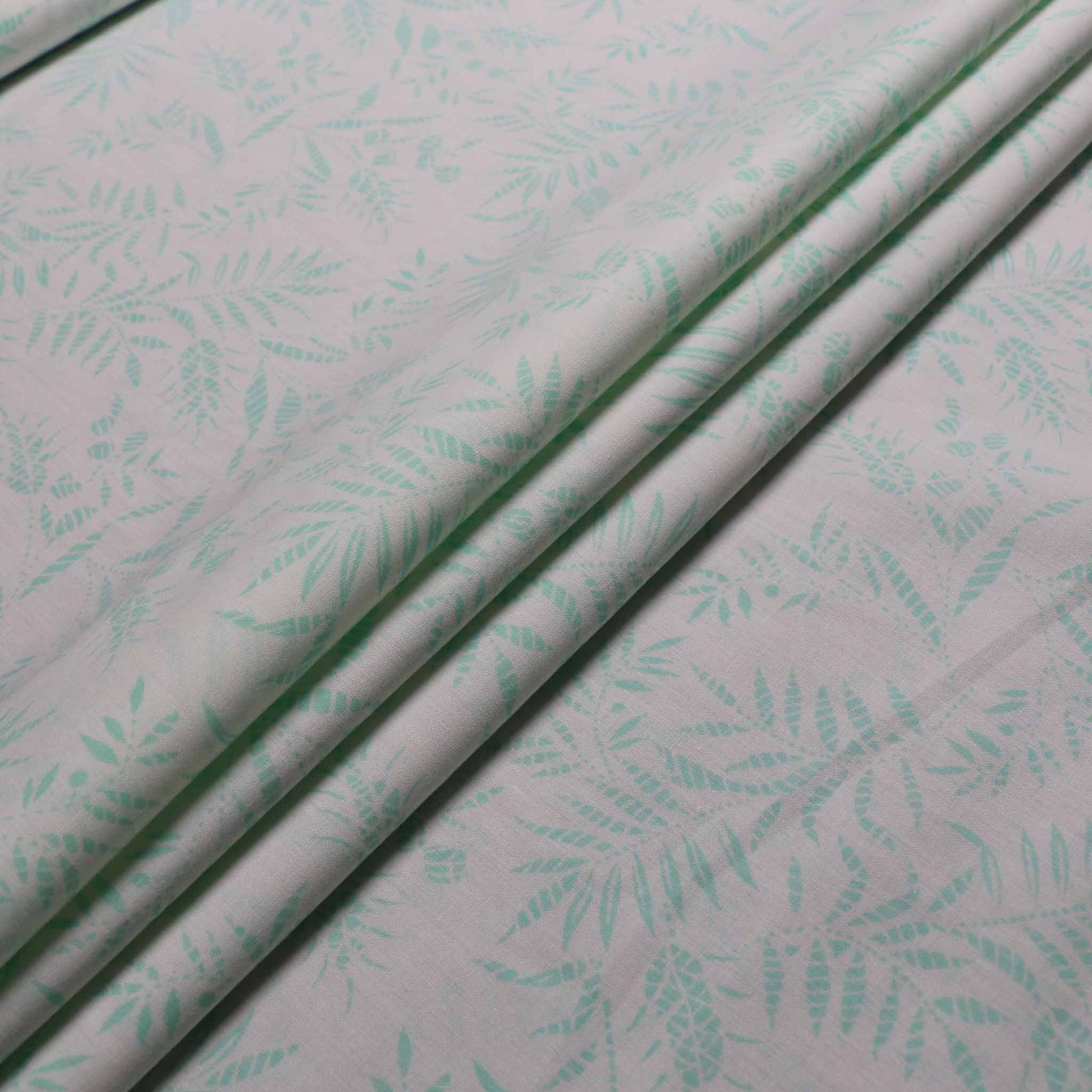 mint leaves printed on white cotton poplin dressmaking fabric