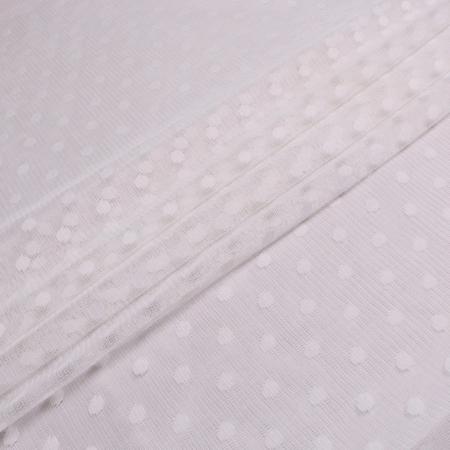folded white netting mesh fabric with polka dot pattern