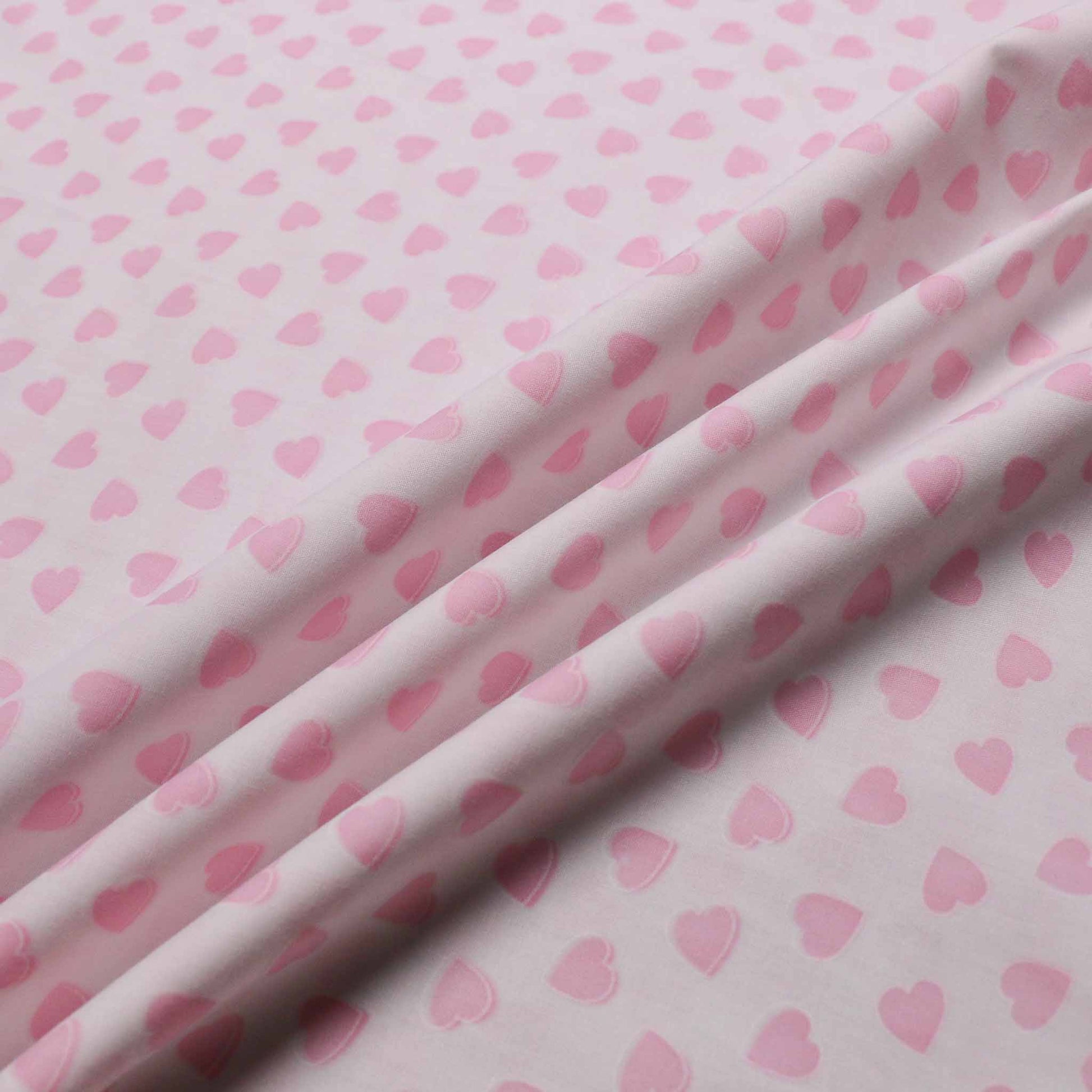 polyccotton dressmaking fabric in white with pink colour love hearts printed