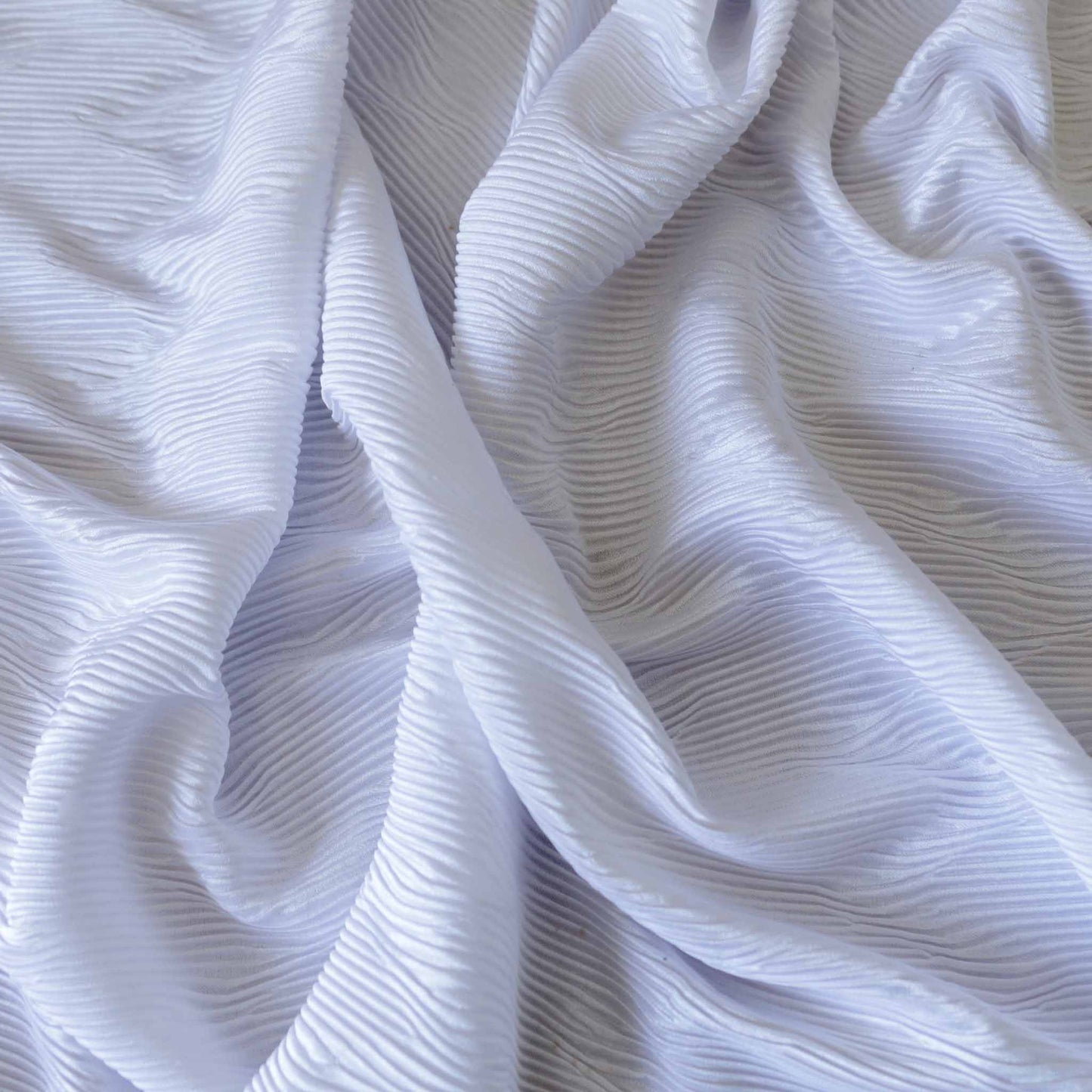 white plisse dressmaking fabric with wavy pleated design