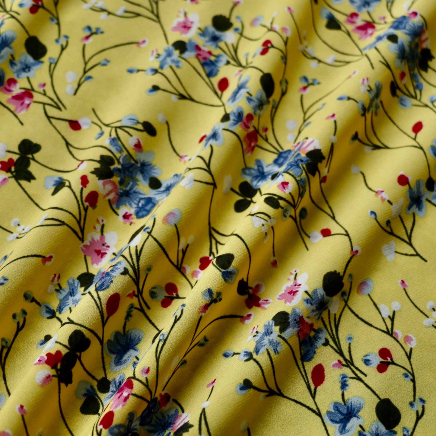 stretchy yellow chiffon polyester dressmaking fabric with black and blue floral print