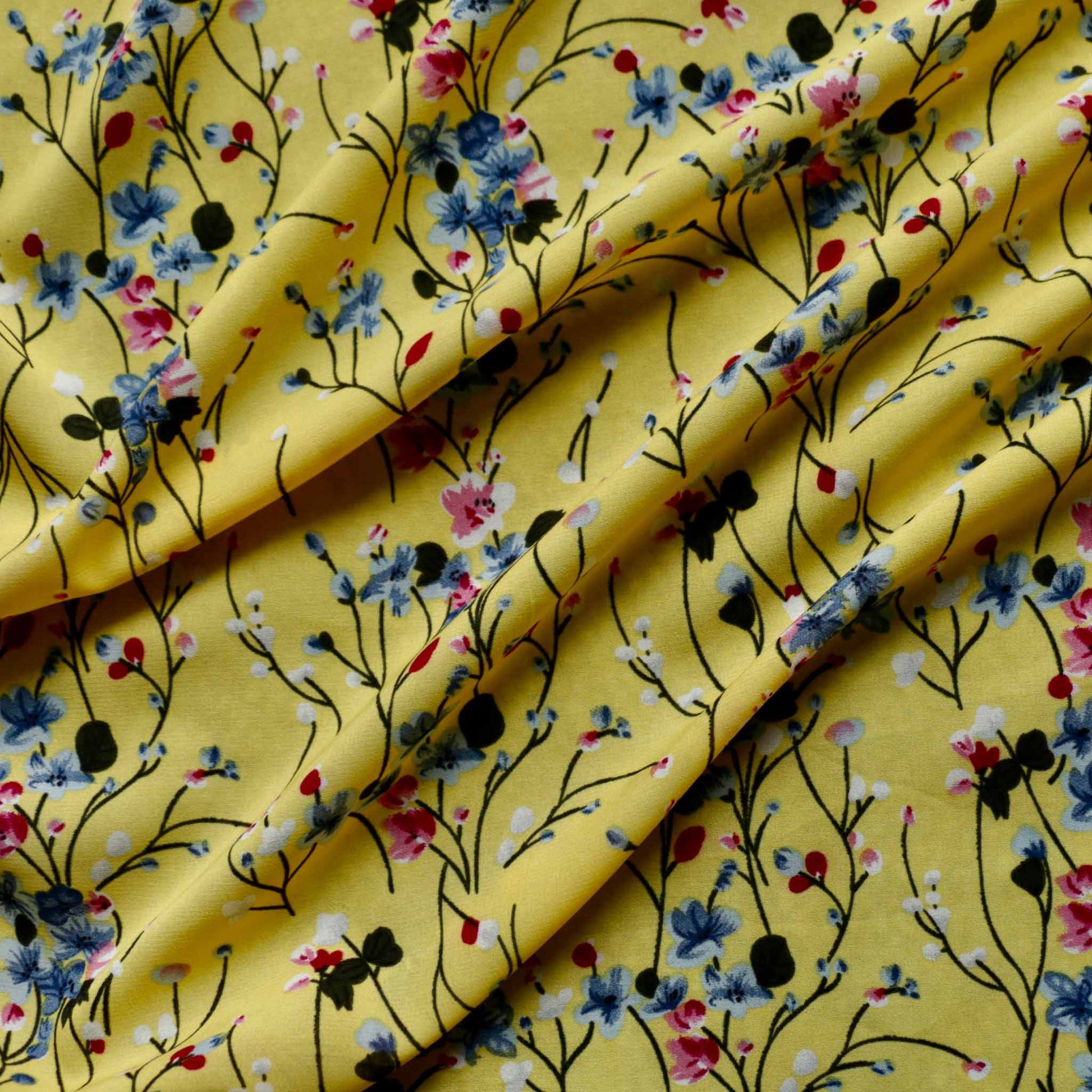 stretchy chiffon polyester dressmaking fabric in yellow with blue and black printed flowers