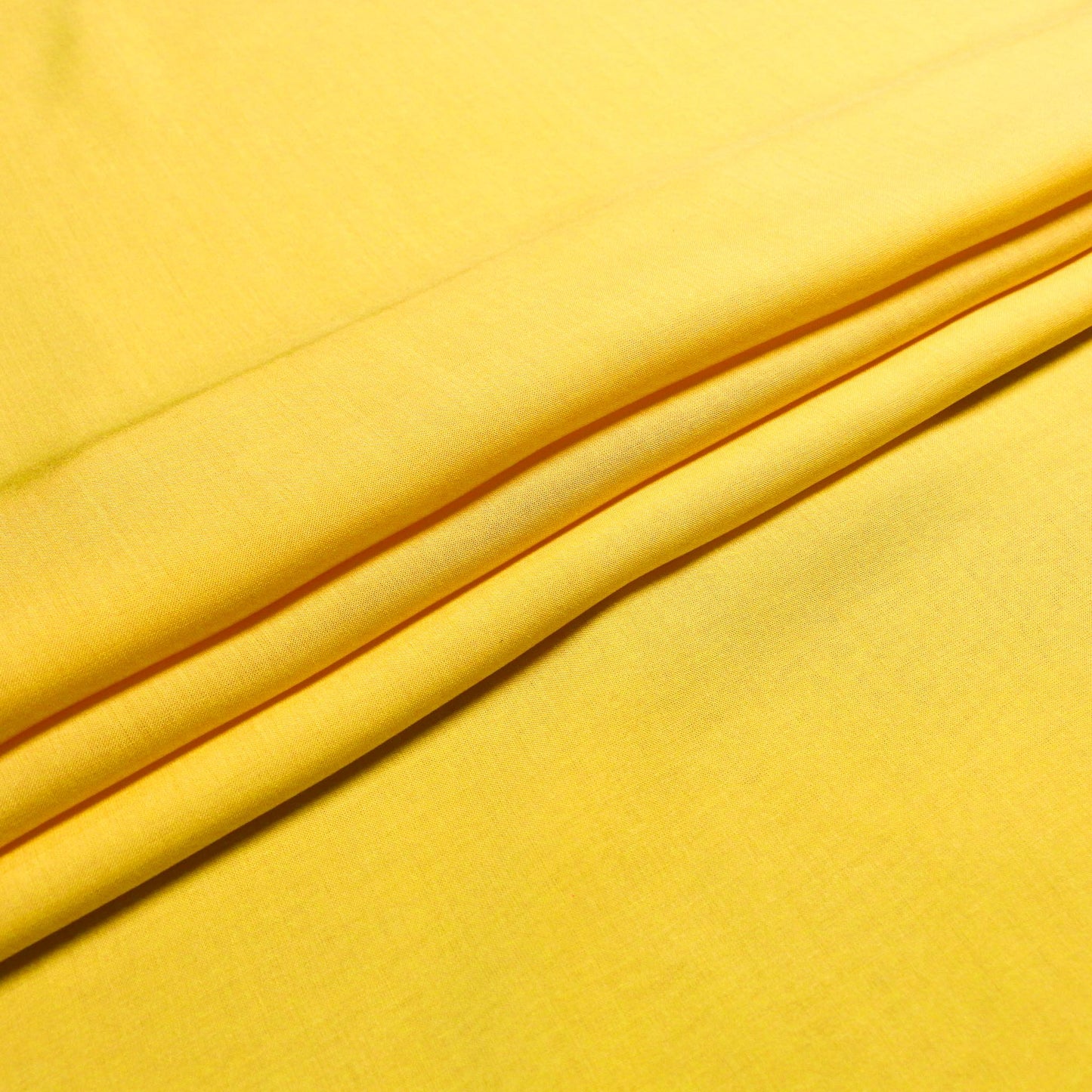 folded yellow viscose voile lawn dressmaking fabric